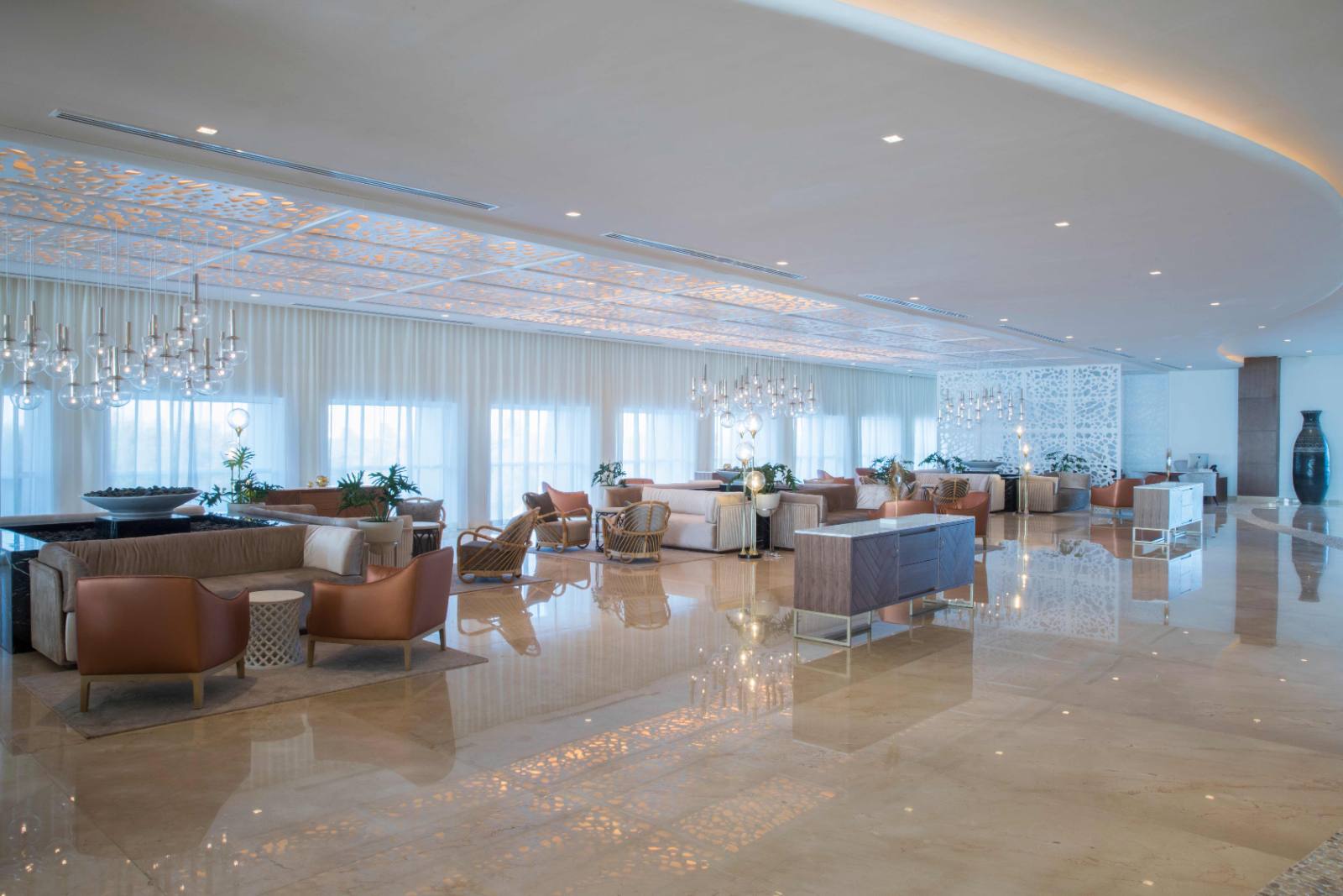 The lobby by day: one long room, curtained to the water, no check-in queue