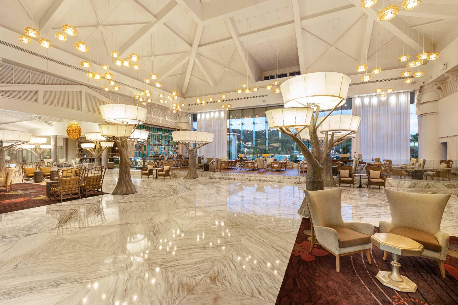 The lobby: tree-form pillars, bar at the back, harbour through the glass