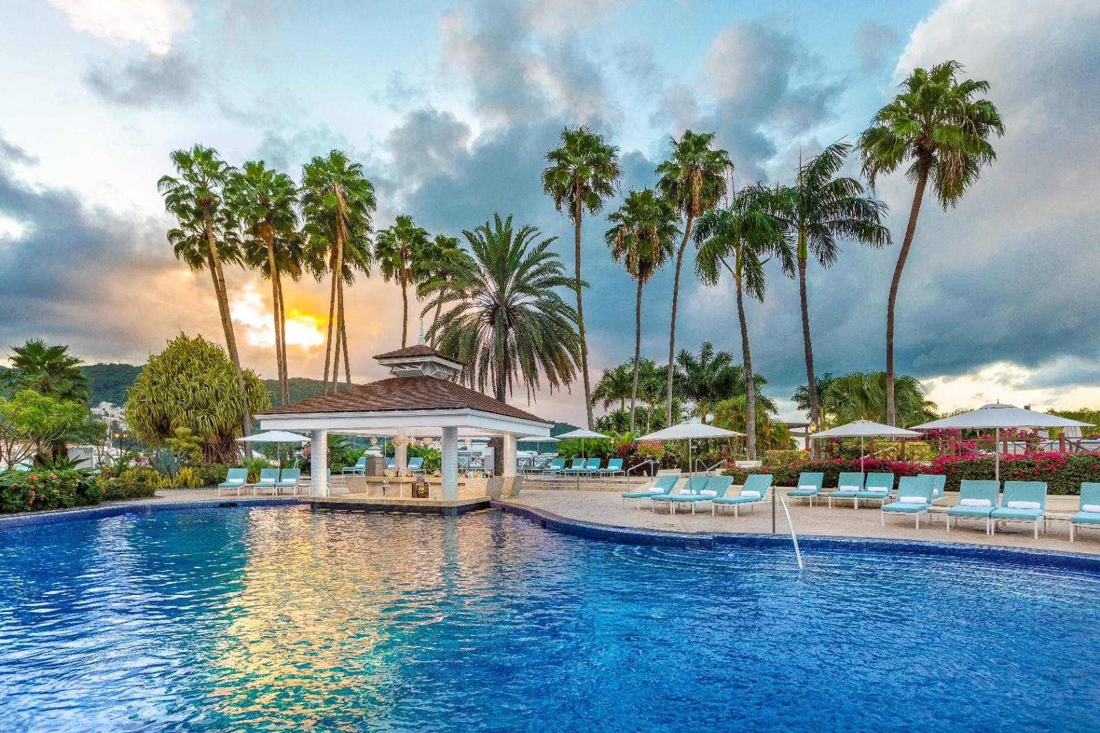 The main pool at sunset: swim-up bar in the middle, Ocho Rios hills behind