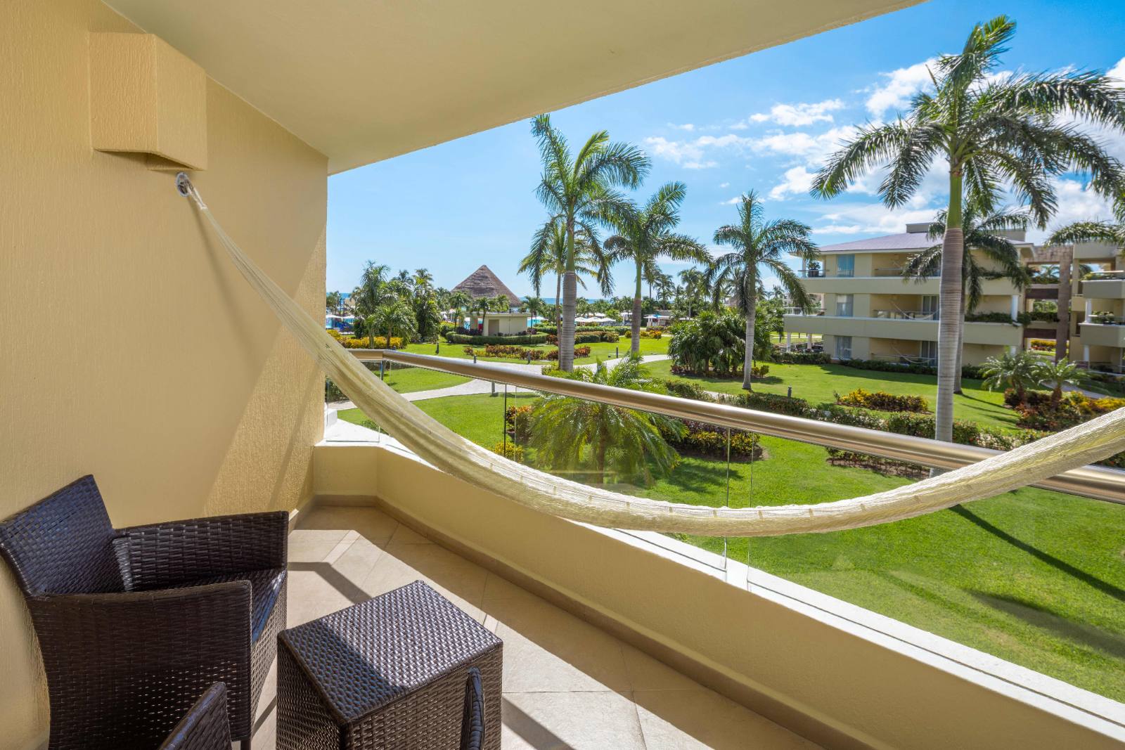 A standard balcony: hammock, two chairs, gardens and the beach beyond