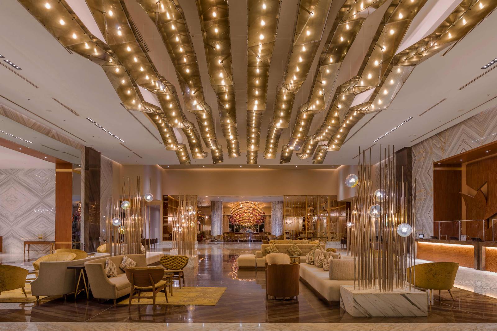 The lobby: brass ceiling, bar at the far end, and a bank of desks off to the right